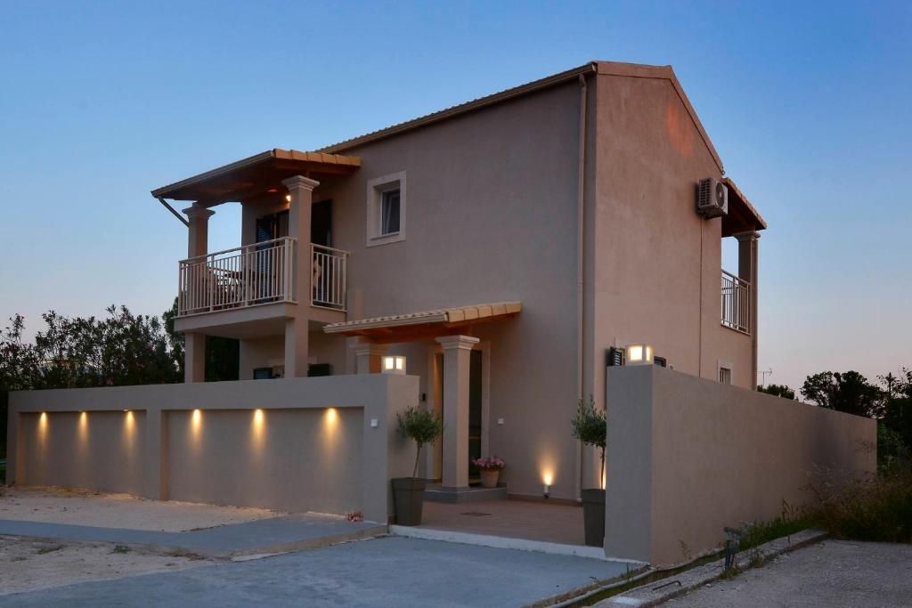 The two-storey villa at dusk with its outdoor lights on, Agios Georgios, Southern Corfu