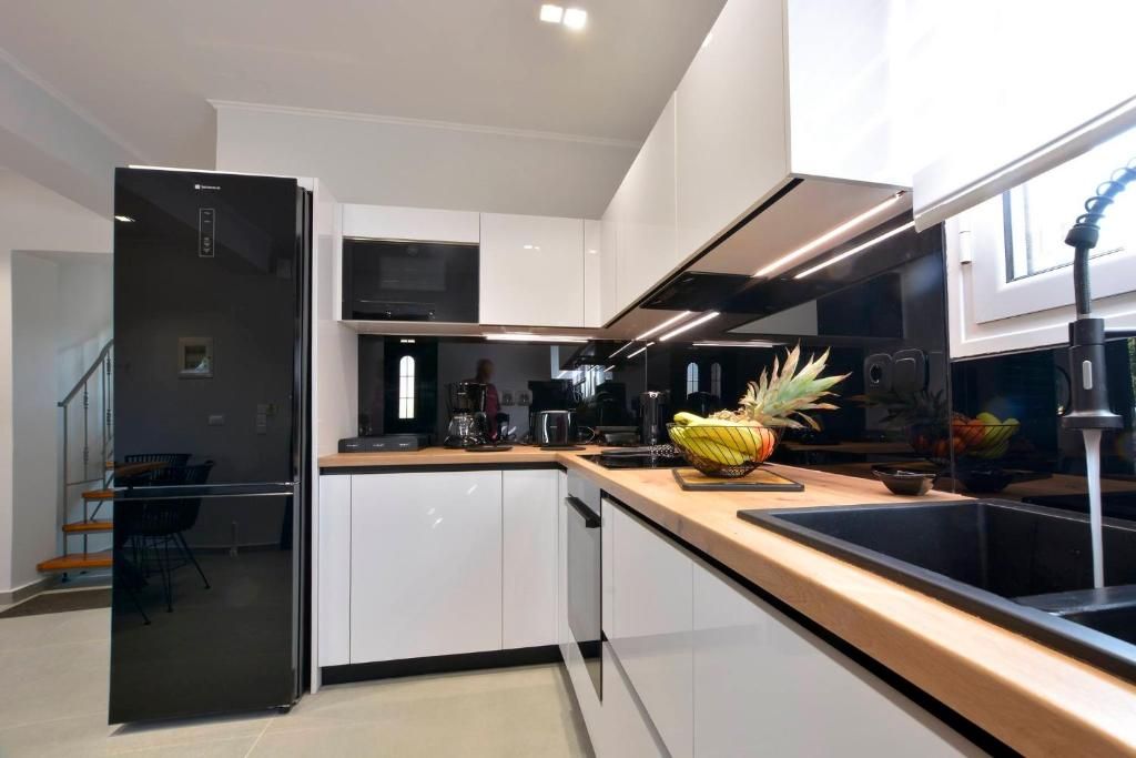 Modern kitchen with refrigerator, oven, stovetop and wooden worktop